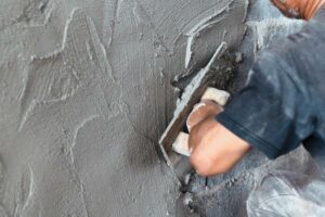 closeup-hand-of-worker-plastering-cement-at-wall-in-construction-site+1