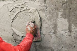 hand-of-worker-plastering-cement-at-wall-for-building-house-in-construction-site+1