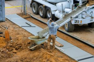 construction-worker-pour-cement-for-sidewalk-in-concrete-works-with-mixer-truck-with-wheelbarrow+1