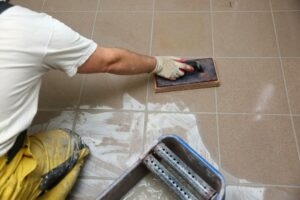 grouting-ceramic-tiles-on-the-floor-by-a-man+1